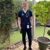 Healthcare worker Veterinarian wearing a navy blue scrub uniform by Dr. Woof